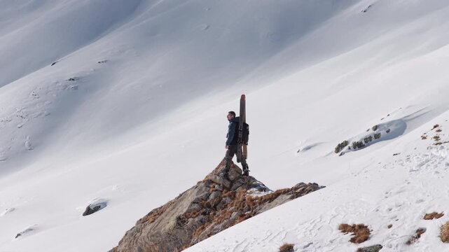  4K 59.94fps Cinematic drone orbit around a ski mountaineer on a rocky summit in Flims Laax, Swiss Alps, surrounded by rugged alpine terrain and snow-covered peaks.