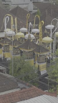 High angle view of traditional Balinese meru shrines with yellow and white ceremonial umbrellas tedung during Galungan festival in Bali Indonesia