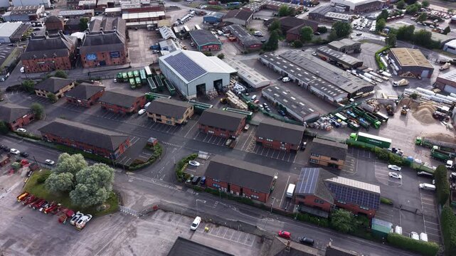 Aerial drone 4K clip showing town buildings backed by woodland greenery under bright natural tones Burton on Trent