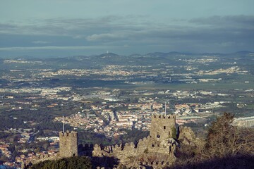 Obraz premium A panoramic view captures the grandeur of medieval castle ruins, standing sentinel over lush valleys and distant towns. The fascinating interplay of history and nature invites exploration and wonder