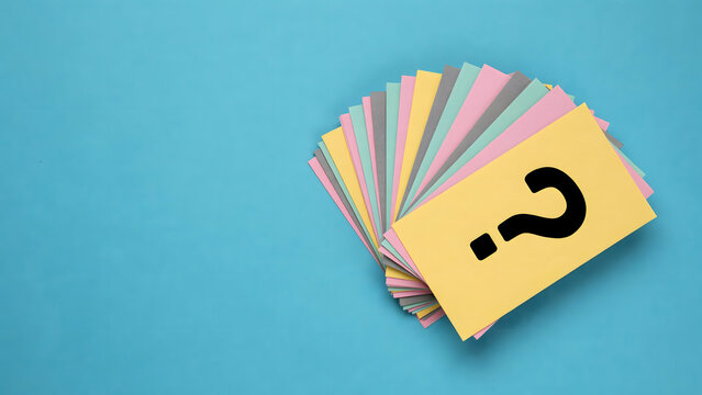 A stack of colorful blank paper cards with a question mark on the top