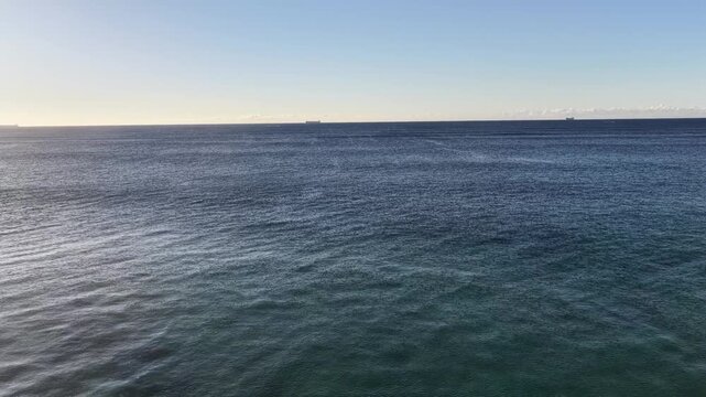 Endless aerial fly over Pacific ocean surface to distant horizon off NSW coast.