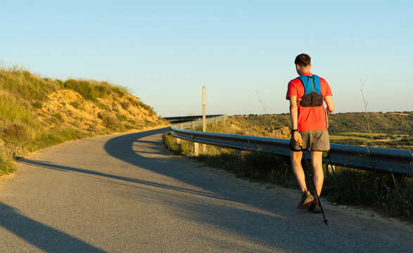 Man speed hiking a winding rural road