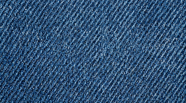 Texture of blue denim fabric with close-up twill weave pattern showing sturdy cotton threads.