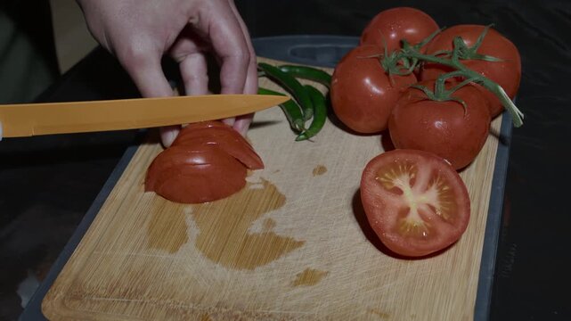 ood preparation concept with a chef chopping ripe tomatoes into small cubes.