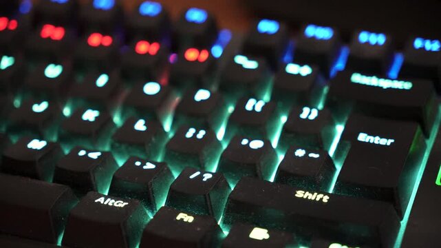 Close-up of RGB backlit mechanical gaming keyboard with colorful LED wave effect.