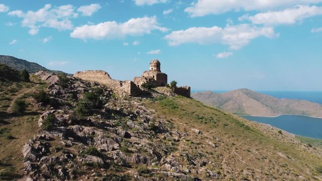 Aerial drone view of the historical Saint Thomas Monastery (Altinsac Monastery) located on a hill overlooking Lake Van in Eastern Turkey. Panoramic view reflecting Turkey's cultural heritage.
