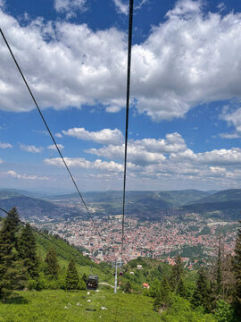 Cable car gondola descending toward Sarajevo city panorama from Trebevic mountain in summer
