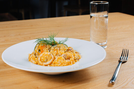 Seafood risotto with squid and shellfish on white plate