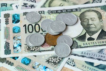 Japanese yen money bills and coins on table. Japan cash of JPY currency close up © Larysa