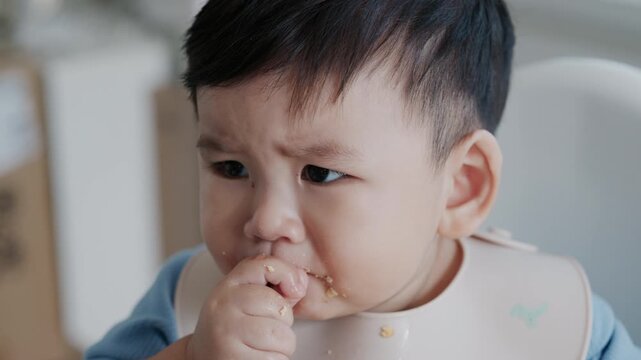 Cute Asian Toddler Eating Finger Food at Home, Healthy Childhood and Family Lifestyle in 4K
