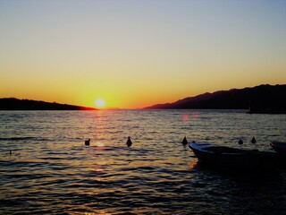 Boat floating on water during tranquil sea sunset © Valenti