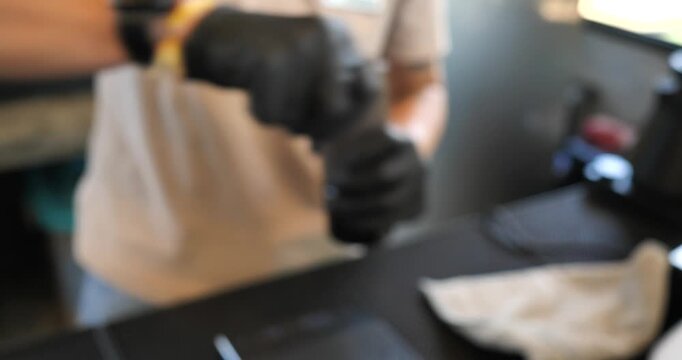  Blurry. A barista is grinding coffee beans in a cafe; the coffee brewing process.