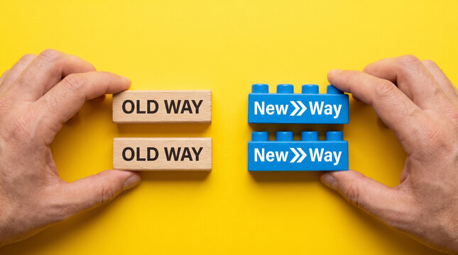 Hands comparing wooden blocks labeled old way against blue plastic bricks marked with new way