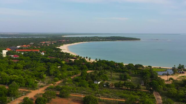 Beautiful sandy beach with palm trees and sea surf with waves. Pasikuda Beach, Sri Lanka.