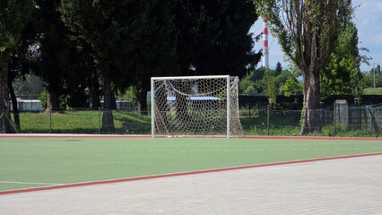 Naklejka premium White metal soccer goal post with net on an outdoor green synthetic turf sports field