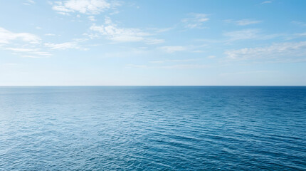 Fototapeta premium Calm blue ocean horizon under a clear sky with light clouds