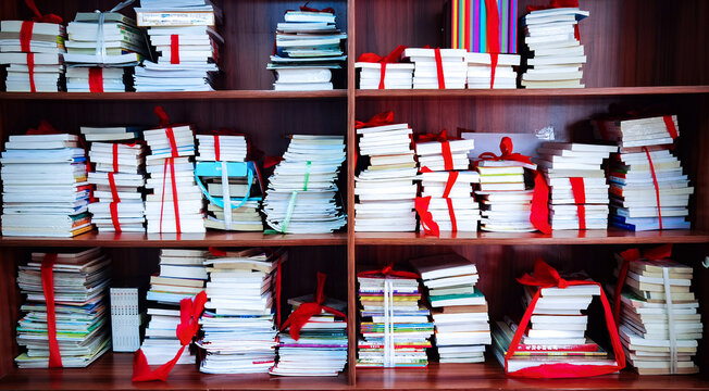Wooden Shelves with Thousands of Neatly Arranged Books and Red Ribbons