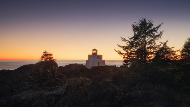 Amphitrite Point Lighthouse at sunset on a rocky headland, Ucluelet, Vancouver Island