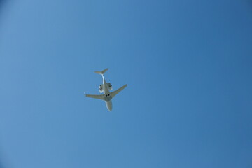 Fototapeta premium White Private Jet Climbing in Blue Sky After Takeoff