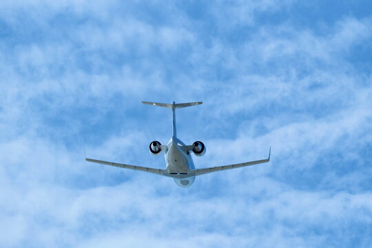 White Private Jet Climbing in Blue Sky After Takeoff