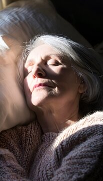 Silver haired woman finds peaceful contentment relaxing on a cushion bathed in soft morning light