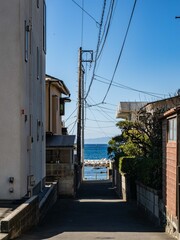 住宅街の路地の先に広がる青い海 © Masanori Saito