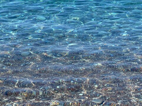 Sea waves crystal clear water on pebble beach for relax.