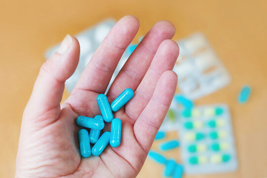 Blue capsules on a woman's palm.