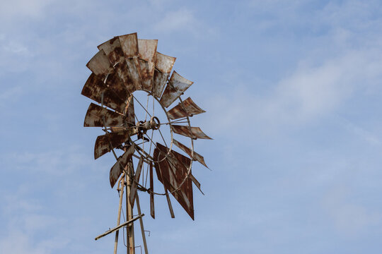 Rustic rusty windmill standing tall under clear blue sky