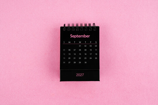 Black calendar for September 2027 year on pink color background.