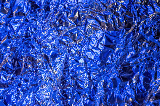 Textura de papel de aluminio arrugado con un intenso reflejo azul met&aacute;lico.