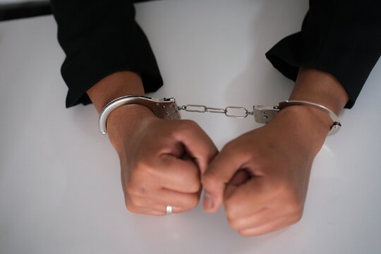 Business woman with handcuffs on a white background. Concept of arrest and crime. World justice day
