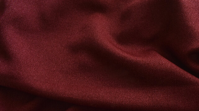Terracotta burgundy fabric texture with soft elegant folds. Closeup abstract draped background of maroon or dark red luxury textile cloth with copy space