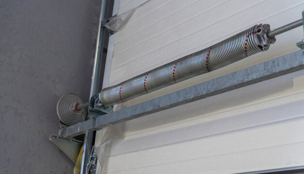 Torsion spring mechanism on sectional garage door
