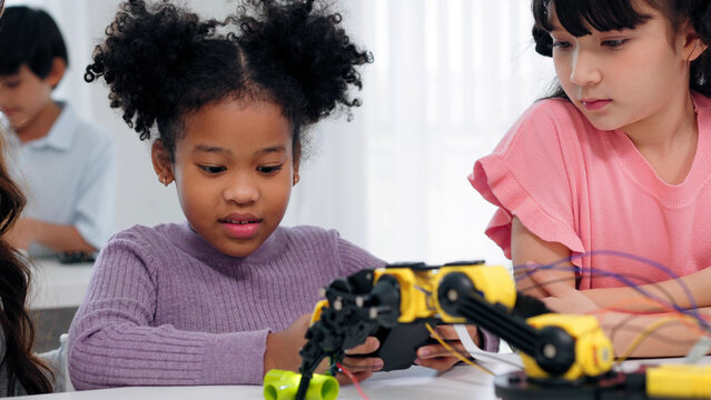A young girl explores robotics and engineering in a STEM classroom. Hands-on technology learning, diverse elementary education, student collaboration, and future skill development