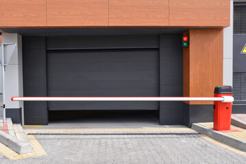 Automatic sectional garage door with closed red boom barrier © Sergey