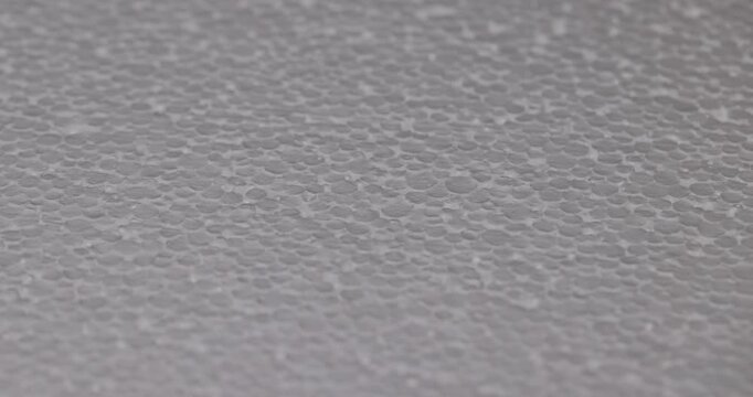 White foam with a granular texture, this foam consists of many small compressed granules in a uniform dense layer.