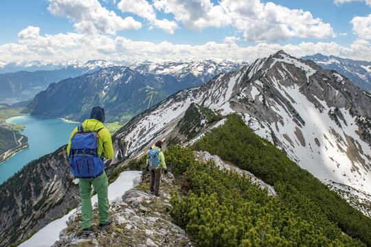 Two hikers on hiking trail, crossing from Seekarspitz to Seebergspitz, view over the lake Achensee, Tyrol, Austria