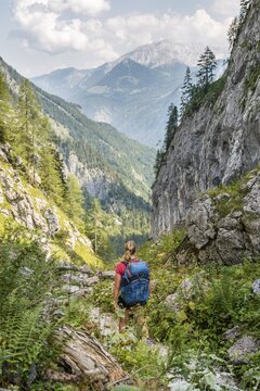 Female hiker on a hiking trail, view of mountains, Saugasse, hiking trail to K&ouml;nigssee and K&auml;rlinger Haus, Berchtesgaden National Park, Bavaria, Germany