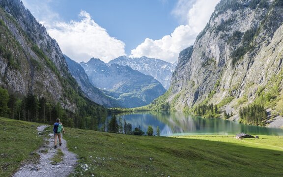 Hiker on trail to Lake Obersee, reflection in water, Salet am K&ouml;nigssee, National Park Berchtesgaden, Berchtesgaden area, Upper Bavaria, Bavaria, Germany