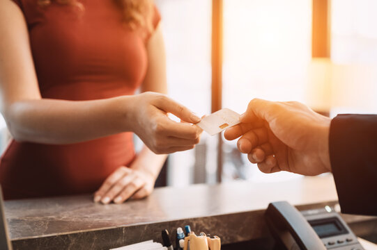Close-up customer hand while paying for services at hotel. Female guest using a credit card for payment. service hotel and payment concept.