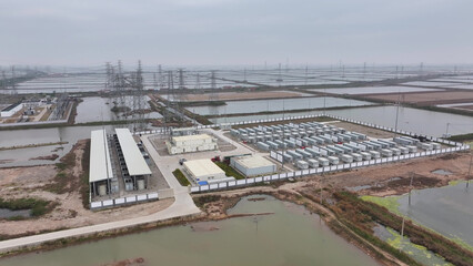 Obraz premium Aerial view of a large-scale energy storage power station with transmission infrastructure and surrounding wetlands
