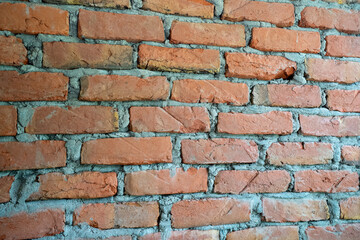 Fototapeta premium Textured red brick wall with rough grey mortar joints
