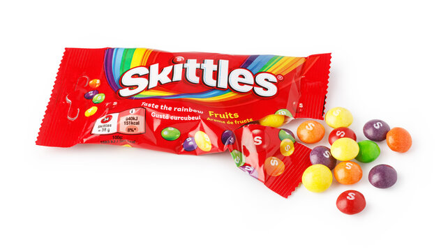 Skittles candy spilled from red packaging with fruit flavors