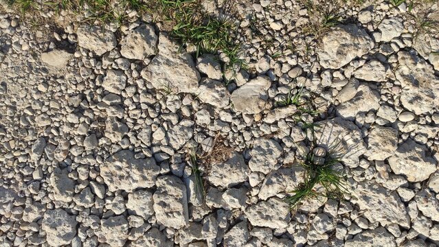 Crushed Limestone Aggregate covering the ground with sharp uneven stones. Use for civil engineering backgrounds, construction material catalogs, and rugged terrain concepts.