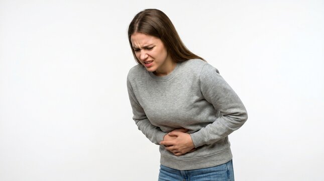 Young woman holding her stomach in pain, suffering from abdominal ache or cramps, isolated on white background