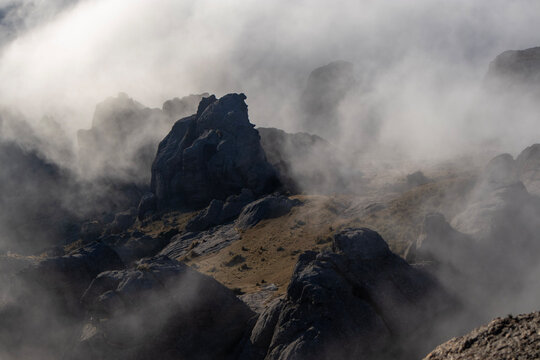 Dramatic mountain peaks shrouded in thick fog and mist