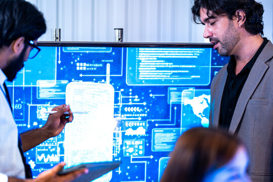South Asian male and Black female professionals celebrate achievements in a dark tech office holding a certificate of recognition.