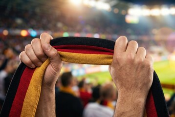 German football fan holding scarf in stadium